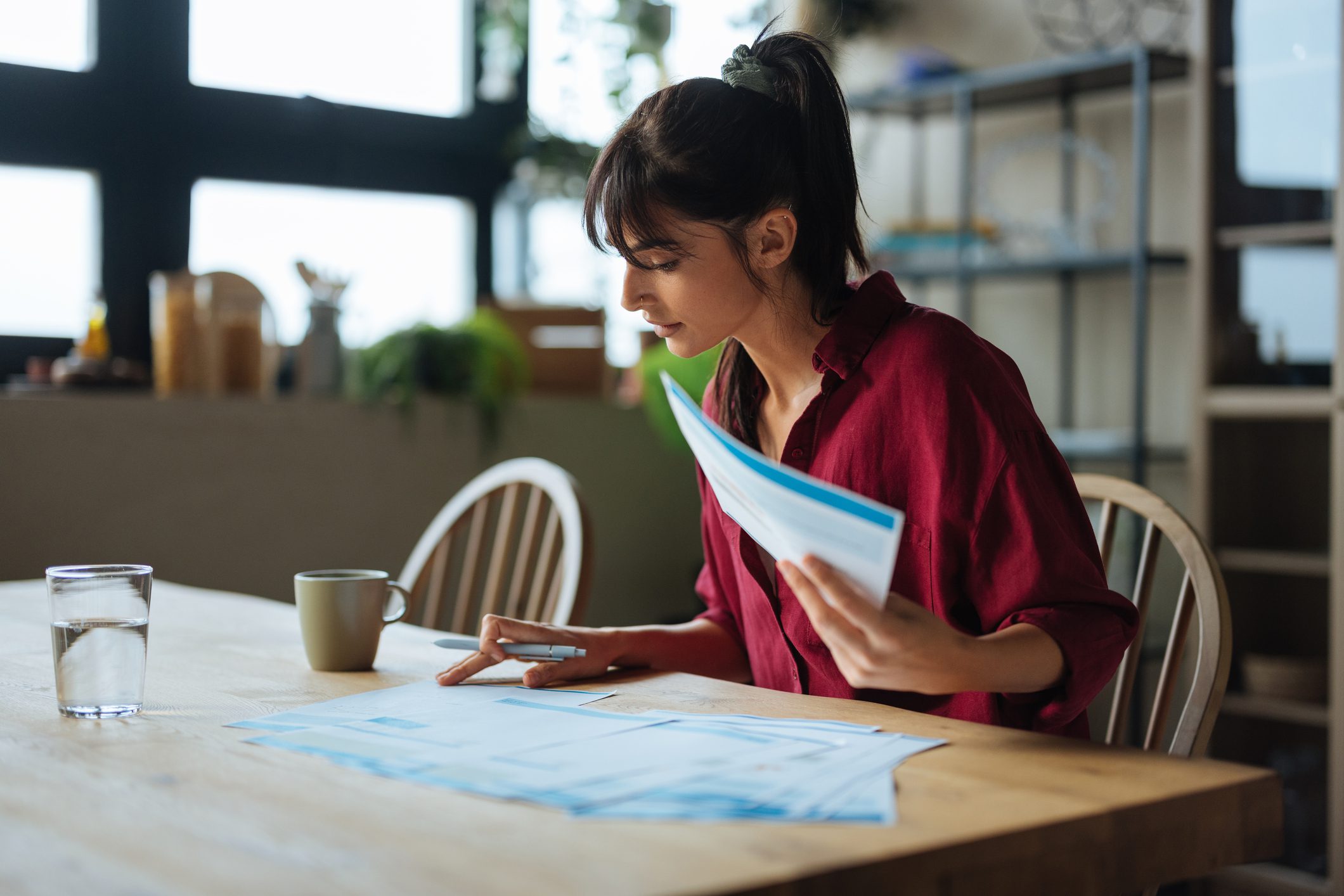 Woman reviewing documents at a table.
