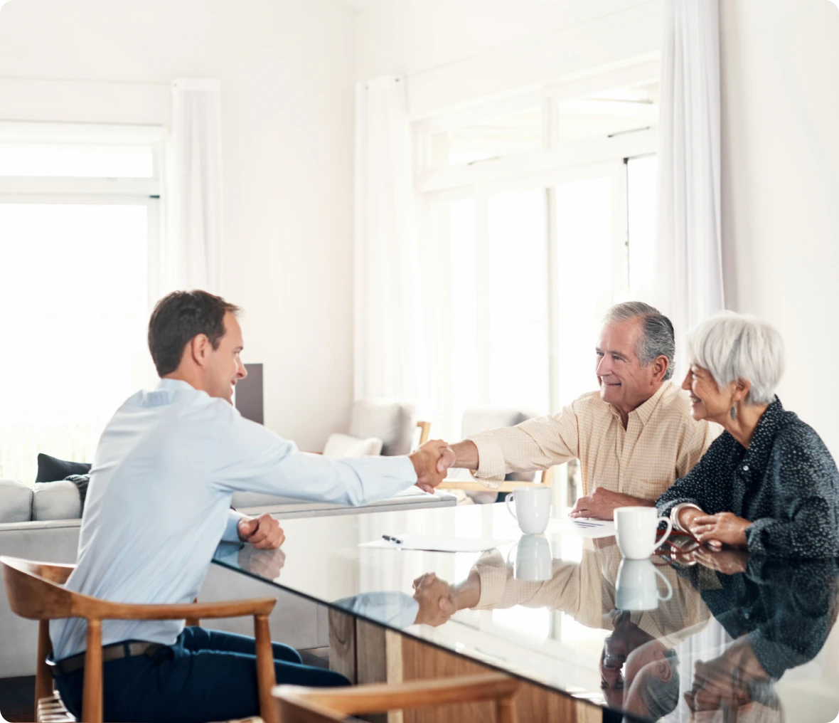 Man shaking hands with elderly couple.